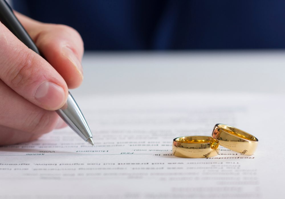 Hands,Of,Wife,,Husband,Signing,Decree,Of,Divorce,,Dissolution,,Canceling