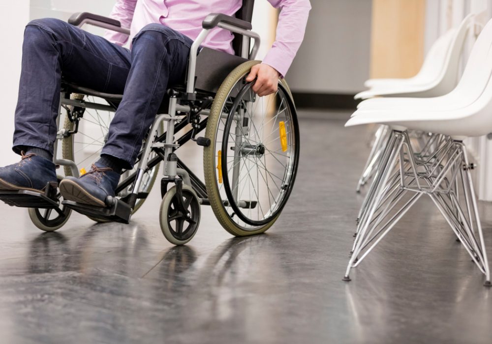 Low,Section,Of,Man,Sitting,On,Wheelchair,At,Hospital,Corridor
