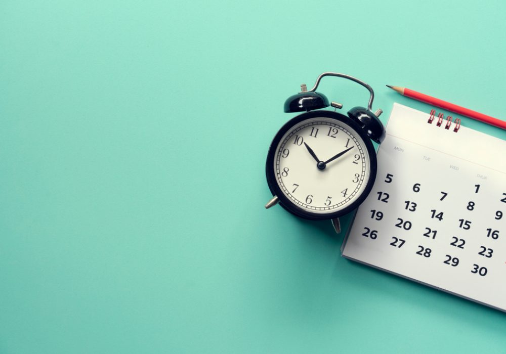 Close,Up,Of,Calendar,And,Alarm,Clock,On,The,Green