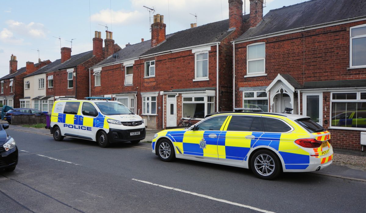 A,Police,Car,And,Van,Parked,Outside,A,Row,Of