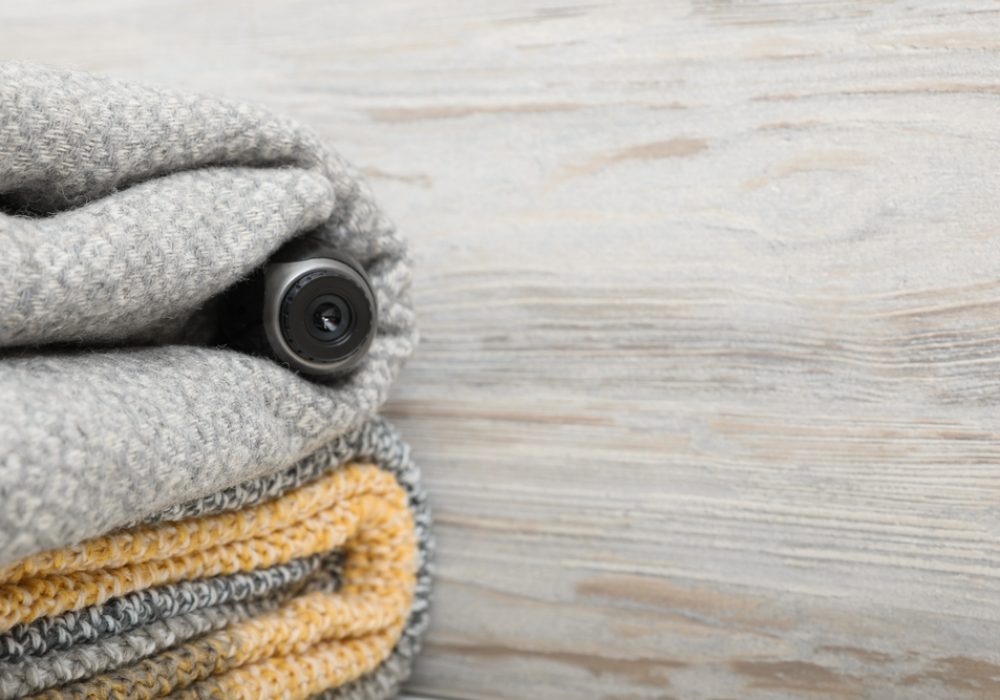Camera,Hidden,In,Plaid,Near,Wooden,Wall,,Space,For,Text