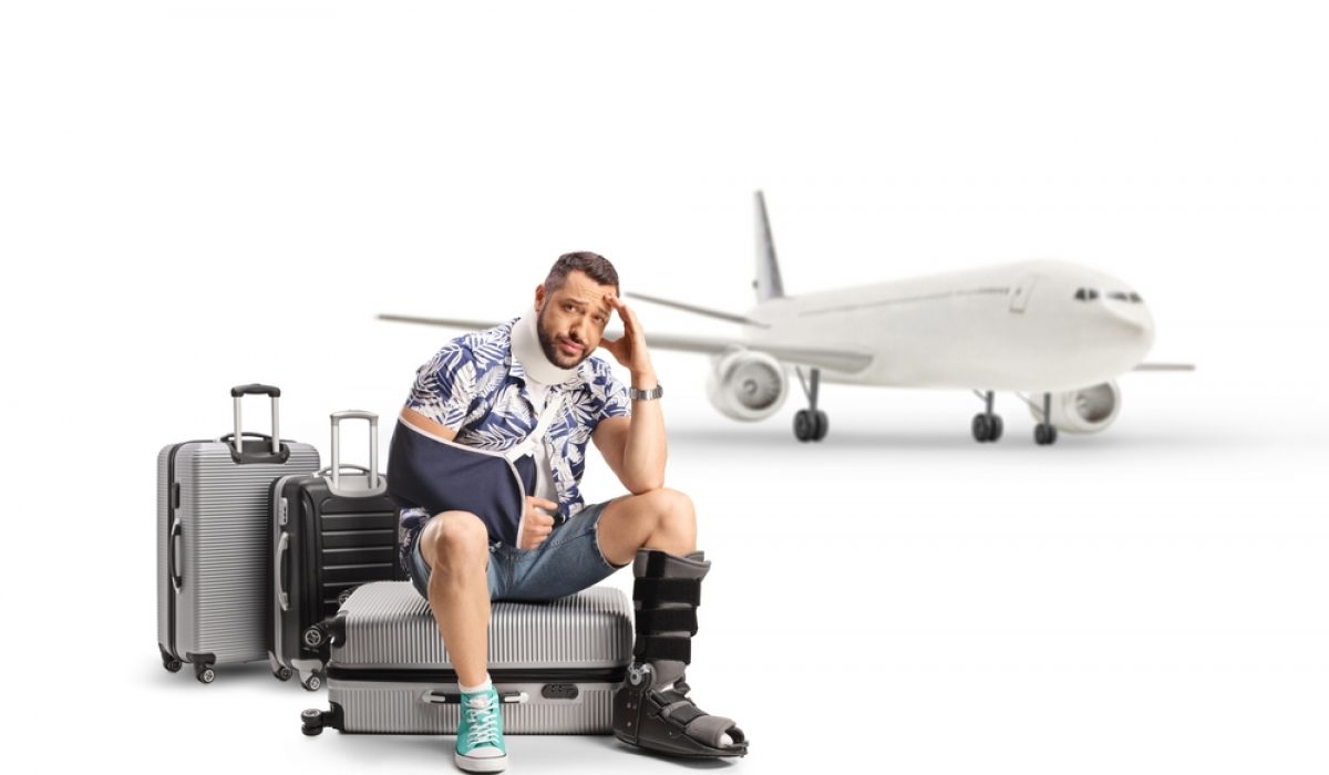 Sad,Male,Tourist,With,An,Injured,Arm,And,Leg,Sitting