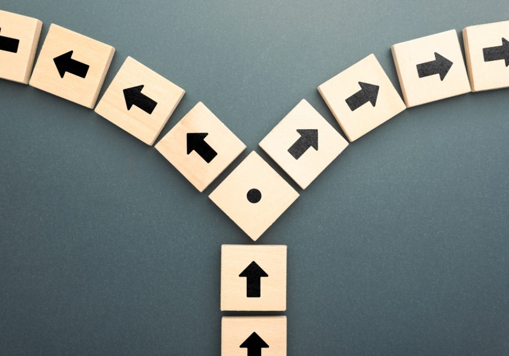 Wooden,Blocks,With,Arrows,Pointing,In,Opposite,Directions,Symbolize,Conflict