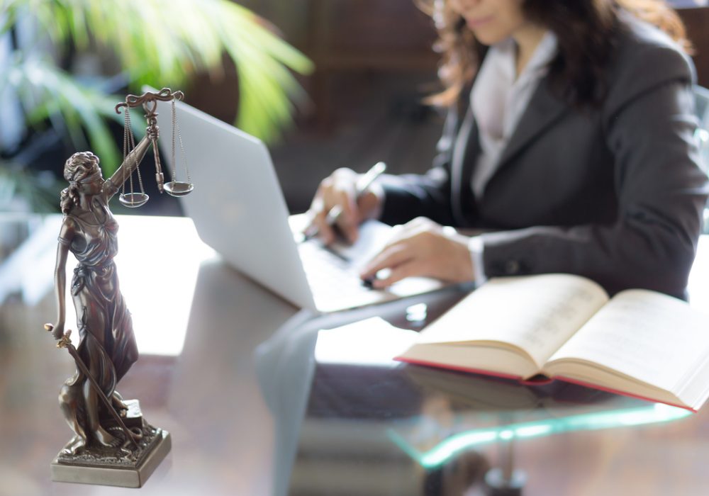 Lawyer,Office.,Statue,Of,Justice,With,Scales,And,Lawyer,Working